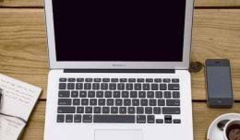 Laptop met mobieltje en kopje koffie